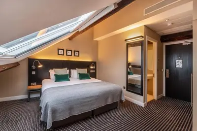 a bedroom with a large bed with a skylight at The Resident Liverpool in Liverpool