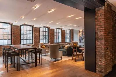 a room with brick walls and tables and chairs at The Resident Liverpool in Liverpool
