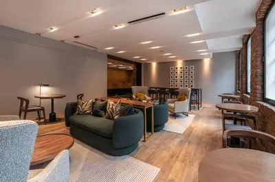 a living room with tables and couches and chairs at The Resident Liverpool in Liverpool