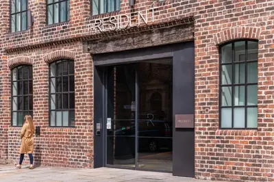 a woman walking in front of a brick building at The Resident Liverpool in Liverpool