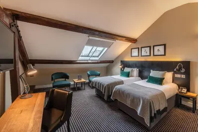 a hotel room with two beds and a table and chairs at The Resident Liverpool in Liverpool