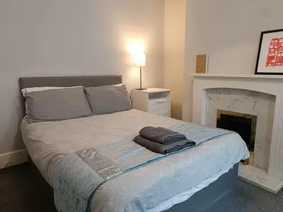 a bedroom with a large bed with a fireplace at Talton House in Liverpool