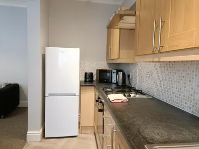 a kitchen with a white refrigerator and wooden cabinets at Talton House in Liverpool