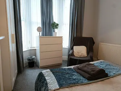 a bedroom with a bed and a dresser and a chair at Talton House in Liverpool