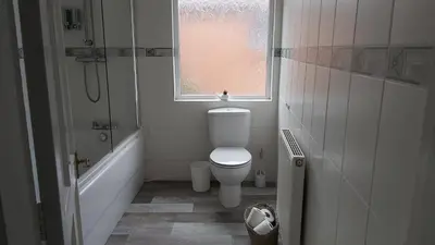 a bathroom with a toilet and a shower and a window at Talton House in Liverpool