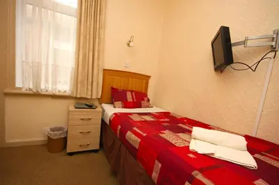 a bedroom with a bed and a tv on the wall at Boltonia in Blackpool