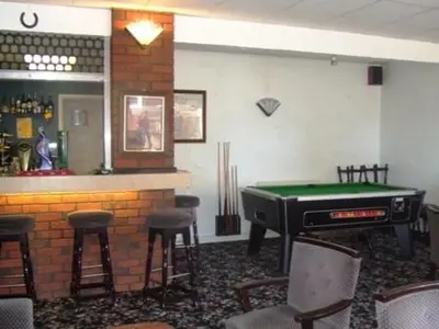 a bar with a pool table in a room with stools at Boltonia in Blackpool