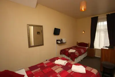 a hotel room with two beds and a mirror at Boltonia in Blackpool