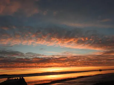 a sunset on a beach with the ocean at The Bay Horse Hotel And Restaurant in Ulverston