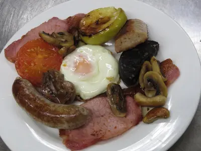a plate of food with eggs sausage mushrooms and tomatoes at The Bay Horse Hotel And Restaurant in Ulverston