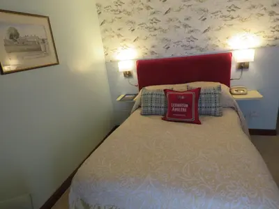 a small bedroom with a bed with a red headboard at The Bay Horse Hotel And Restaurant in Ulverston