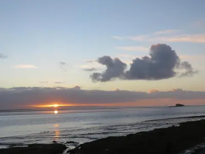 a sunset on the beach with the sun setting at The Bay Horse Hotel And Restaurant in Ulverston