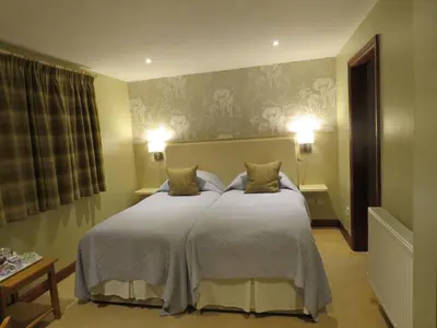 a bedroom with a large bed with two pillows at The Bay Horse Hotel And Restaurant in Ulverston