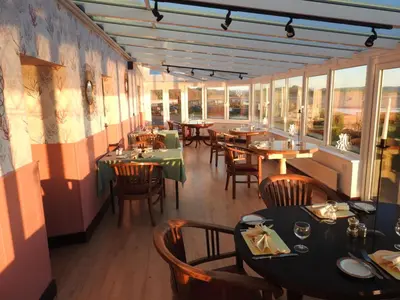 a restaurant with tables and chairs and windows at The Bay Horse Hotel And Restaurant in Ulverston