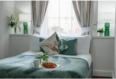 a bedroom with a bed with a plate of food on it at Elysium Liverpool in Liverpool