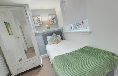 a small bedroom with a bed and a mirror at Elysium Liverpool in Liverpool