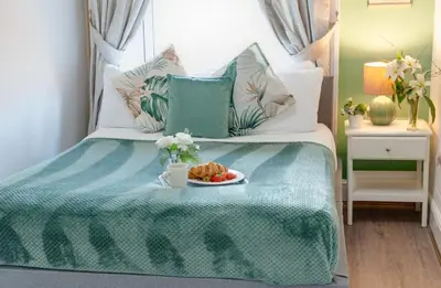 a bedroom with a bed with a plate of food on it at Elysium Liverpool in Liverpool