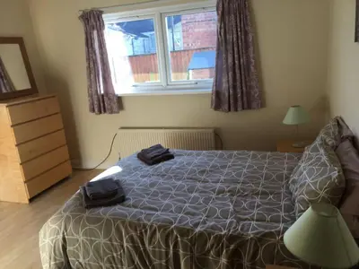 a bedroom with a bed and a window at MARLEY MANSIONS APARTMENT - Clarendon in Wallasey
