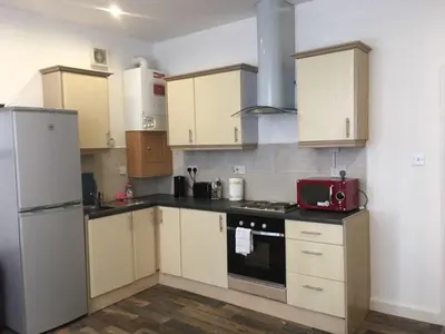 a kitchen with white cabinets and a red microwave at MARLEY MANSIONS APARTMENT - Clarendon in Wallasey