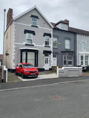 a red car parked in front of a house at MARLEY MANSIONS APARTMENT - Clarendon in Wallasey