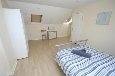 a bedroom with a bed with a blue and white striped blanket at MARLEY MANSIONs APARTMENTS - KING ST REF : 10/3 in Wallasey