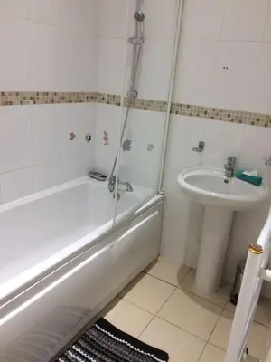 a bathroom with a bath tub and a sink at MARLEY MANSIONs APARTMENTS - KING ST REF : 10/3 in Wallasey
