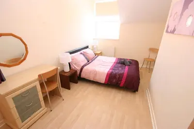 a small bedroom with a bed and a desk at MARLEY MANSIONs APARTMENTS - KING ST REF : 10/3 in Wallasey