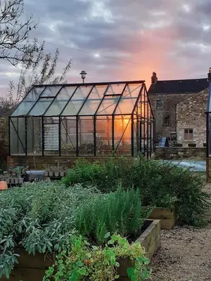 a greenhouse in a garden with some plants at Lancaster Barn in Lancaster