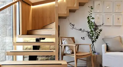 a wooden staircase in a living room with a chair at Lancaster Barn in Lancaster