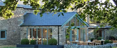 a house with a conservatory with tables and chairs at Lancaster Barn in Lancaster