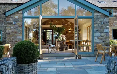 a glass house with a patio with tables and chairs at Lancaster Barn in Lancaster