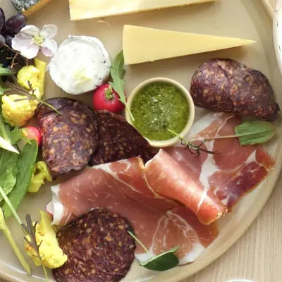 a plate of food with meat and cheese and other foods at Lancaster Barn in Lancaster