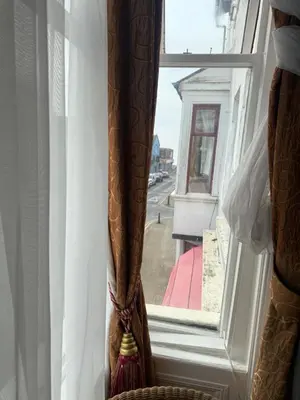 a window with curtains and a view of a street at The Aberford in Blackpool