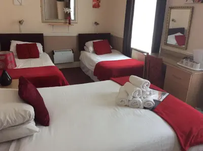 a hotel room with two beds with red and white sheets at The Aberford in Blackpool