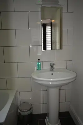 a white bathroom with a sink and a mirror at Sunnyside Guest House Southport - winner of Best B&B in the country 2025-26 in Southport