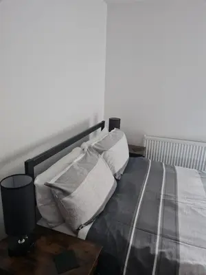 a bedroom with a bed with two pillows and a table at The Last Post in Blackpool