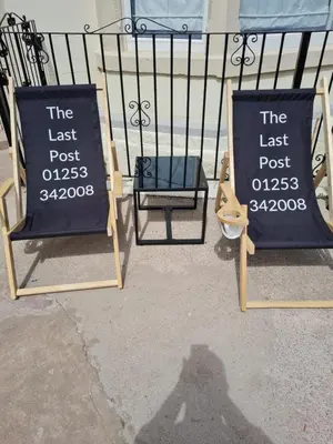 a couple of signs sitting next to a fence at The Last Post in Blackpool