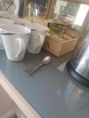 a counter with three cups and a spoon on it at The Gatsby Blackpool - Formerly The Windsor in Blackpool