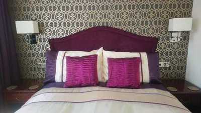 a bedroom with a bed with purple and white pillows at The Gatsby Blackpool - Formerly The Windsor in Blackpool