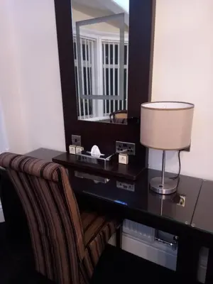a desk with a lamp and a mirror in a room at The Gatsby Blackpool - Formerly The Windsor in Blackpool