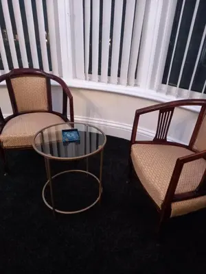 two chairs and a table in a room with windows at The Gatsby Blackpool - Formerly The Windsor in Blackpool