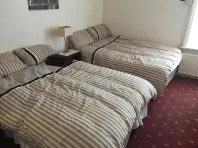 two beds and a couch in a hotel room at The Midway in Blackpool