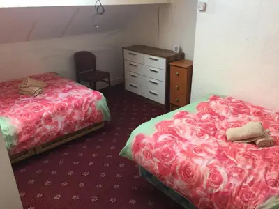 a hotel room with two beds and a dresser at The Midway in Blackpool
