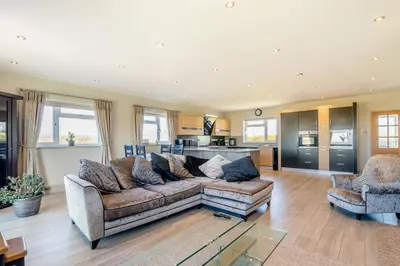 a living room with a couch and two chairs at Palms Cottage in Blackburn