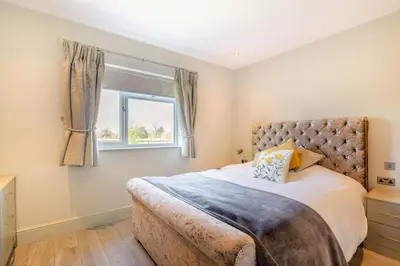 a bedroom with a large bed and a window at Palms Cottage in Blackburn