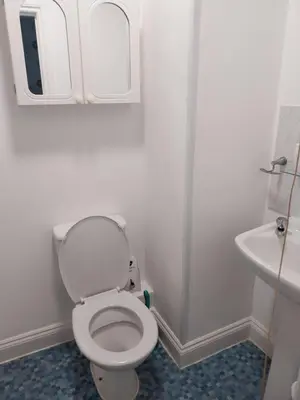 a white bathroom with a toilet and a sink at Delamere Hotel in Blackpool