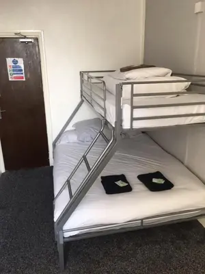two bunk beds in a small room with towels at MyRoomz Seaview Hotel in Blackpool