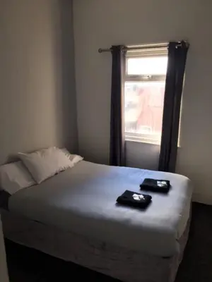 a bed in a room with a window with two dishes on it at MyRoomz Seaview Hotel in Blackpool