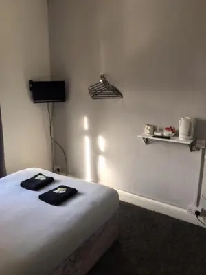 a bedroom with a bed and a shelf on the wall at MyRoomz Seaview Hotel in Blackpool
