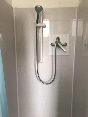 a shower with a hose attached to a wall at MyRoomz Seaview Hotel in Blackpool